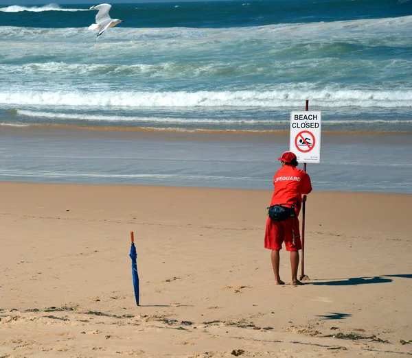 Hombre con signo de lectura playa cerrada — Foto de Stock