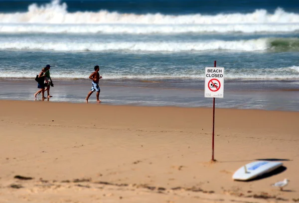 Letrero de playa cerrada y personas — Foto de Stock