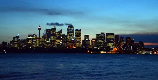 Сіднейський оперний театр і хмарочоси на заході сонця — стокове фото