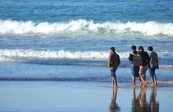 Young men walking on beach — Stock Photo, Image