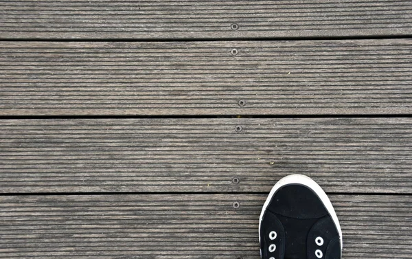 Black and white Shoes stand on old wooden pier floor — Stock Photo, Image