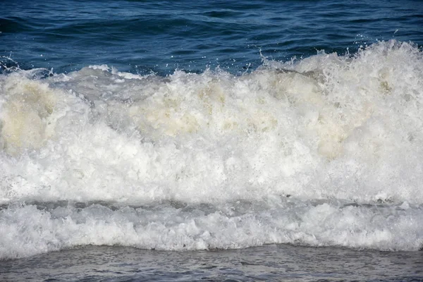 Air busa gelombang menghancurkan ke pantai — Stok Foto