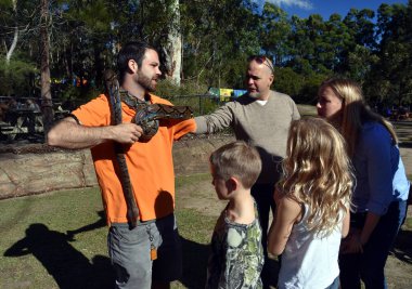 Bir yılan gösteren ziyaretçiler için hayvan bekçisi