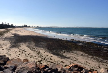 İnsanlar rahatlatıcı ve Stockton kumsalda güneşlenme. Stockton köprü içinde belgili tanımlık geçmiş.