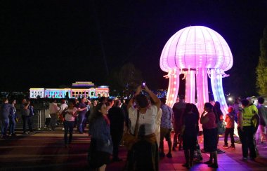 Canberra, Avustralya - 10 Mart 2018. İnsanlar Canberra 2018 Enlighten Festivali sırasında büyük parlak ahtapot heykel izliyor. Eski Meclis evi Avustralya içinde belgili tanımlık geçmiş.