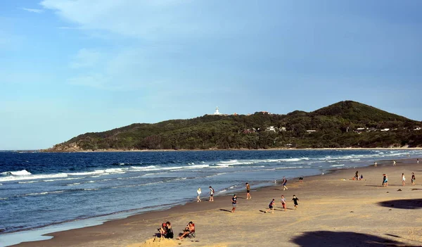 Byron Bay, Avustralya - 24 Aralık 2017. İnsanlar mavi gökyüzü ile güneşli öğleden sonra Byron sahilde rahatlatıcı.