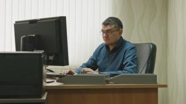 İn Office: bilgisayarda, geniş açı çalışma bardaklarda çalışan adam