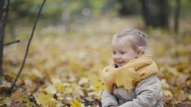 Anne ve kızı küçük kız bir sonbahar park - anne ve çocuk yürüyüş var eğlenceli ve sarı yapraklarda oynama