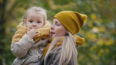 Anne ve kızı küçük kız bir sonbahar park - anne ve çocuk oynarken iyi eğlenceler ve iplik, yakın çekim