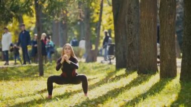 Genç fitness kadın modeli sonbahar Park'ta bir çayırda egzersiz, spor açık hava etkinlikleri kavramı - ağız kavgası
