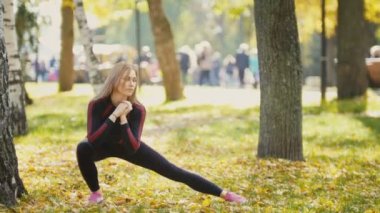 Seksi çekici kadın sarışın bikini-fitness modeli zeminde sonbahar parkta uzanan sarı yapraklar - bacaklar esneklik kaplı