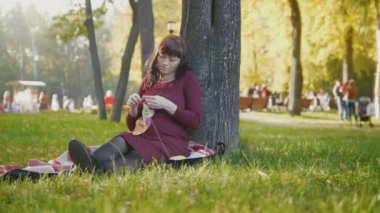 Güzel hamile kadın sonbahar Park yapmak hobi örgü iğneleri