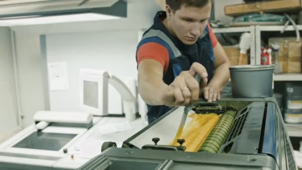 Werknemer op Polygrafie drukkerijen gebruiken gele verf op Inktrol — Stockvideo