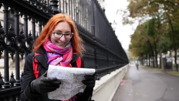 Yong kvinna turist med rött hår och glasögon tittar karta i Wien nära Neue Burg, Österrike — Stockvideo