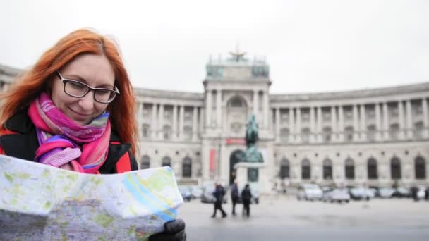 Yong turistické - žena s rudými vlasy a brýle hledá mapu v Heldenplatz, Vídeň — Stock video