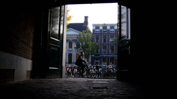 AMSTERDAM, NETHERLANDS - view of street with tourists, bicycles and canal, silhouette — ストック動画