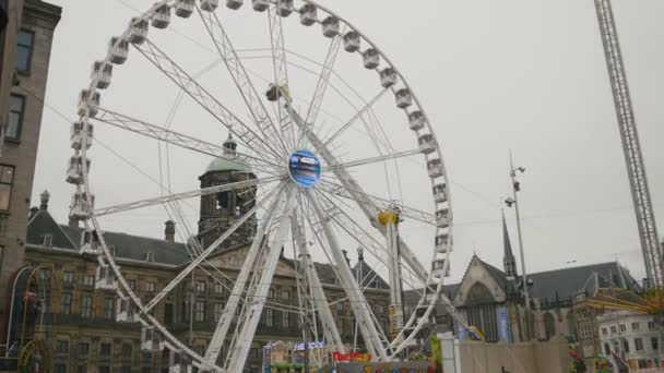 AMSTERDAM, PAÍSES BAJOS - 16 oct 2016, Parque de Atracciones - Rueda de la fortuna en la plaza Dam - centro histórico de Holanda CAPITAL, telephoto — Vídeo de stock