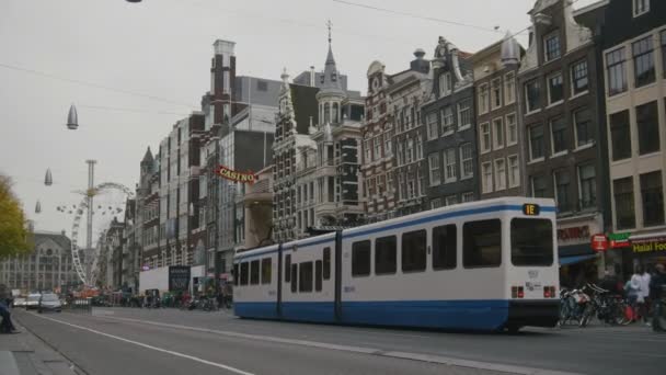 AMSTERDAM, NETHERLANDS - 16 oct 2016, tourists on the street, bicycle and cars - The tram rides through the historic center — ストック動画