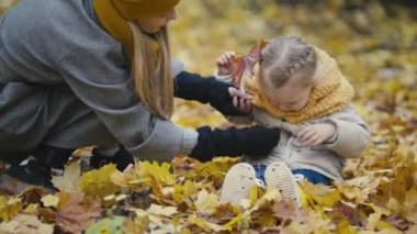 Mutlu aile kavramı - sonbahar Park sarı yaprakları ile küçük kızı annesiyle birlikte çalış