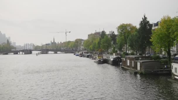 Fartyg och husbåtar längs Amstel kanalerna, Amsterdam, Nederländerna — Stockvideo