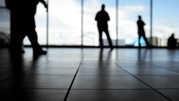 Wachten voor aanhouding voor raam in de luchthaven, passagiers silhouet — Stockvideo