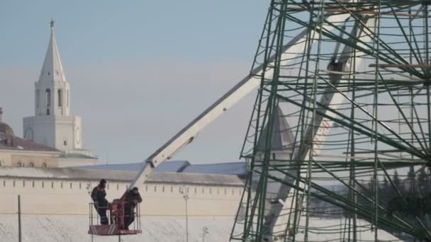1 ДЕКАБРЯ 2016, КАЗАНЬ, РОССИЯ, строительство нового года - два рабочих на грузовике с мобильным краном для установки металлического дерева — стоковое видео