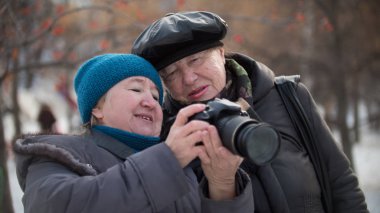 Onlar için kendini arayan iki kadın kıdemli kış günü, açık, fotoğraf makinesi