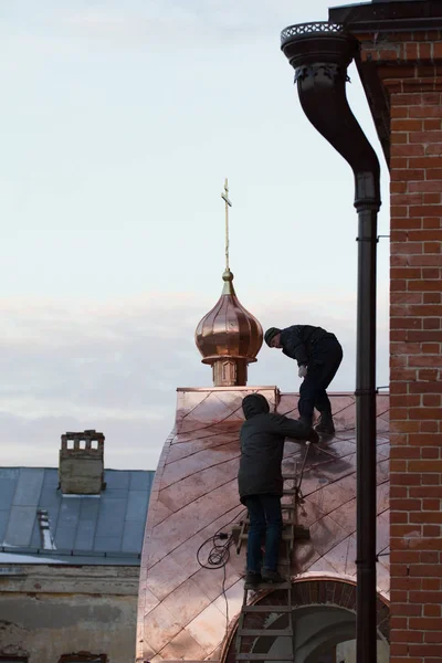 KAZAN, RUSIA, 19 DE NOVIEMBRE DE 2016, dos trabajadores Roofer reparación de techo de ortodox Viejos creyentes Iglesia en invierno día frío — Foto de Stock