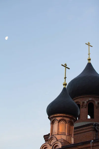 Campanario de la antigua iglesia ortodoxa creyente en la madrugada de invierno, cruza con la luna en el cielo — Foto de Stock