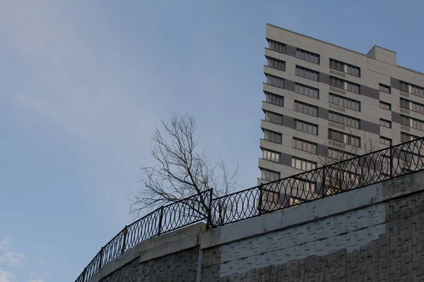 Architektonische Hintergründe: modernes Gebäude auf hohem Hügel mit getrocknetem Baum — Stockfoto