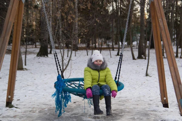 Gelukkig kind: meisje op de childrens rocker in winter city park — Stockfoto