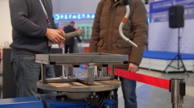 İki adam robotik kol için technowelding için endüstriyel sergi arıyor.