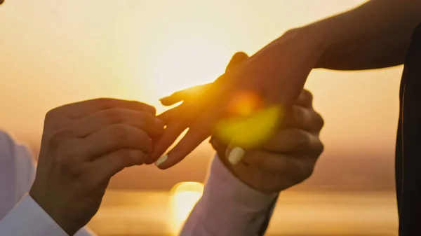 Свадебное кольцо Положите на пальцы руки касаясь заката жених жених Мужчина Женский брак Предложение отпуск медовый месяц, горизонтальный — стоковое фото