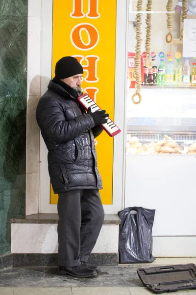 Kazan, Rusland - 11 December 2016: straat muzikant volwassen arme man in metropolitan speelt op muziekinstrument. winterdag — Stockfoto