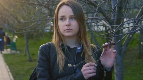 Söt ung flicka som står i parken vid solnedgången — Stockfoto