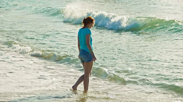 Jeune femme avec de longs cheveux rouges sauter et jouer vagues de mer, plage de paysage marin de la République dominicaine — Photo