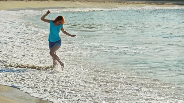 Giovane donna con lunghi balli rossi sulla spiaggia estiva della Repubblica Dominicana — Foto Stock