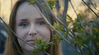 Sevimli genç kız parkta duran ve kamera, yakın yukarı bakıyor