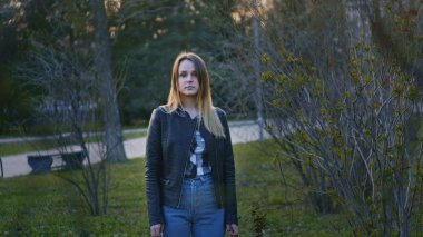 Sevimli genç kız parkta duran ve kamera bakıyor