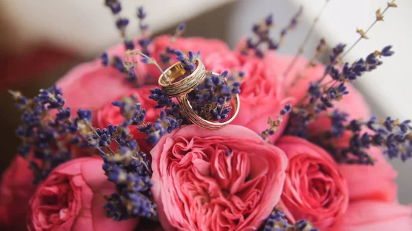 Golden wedding rings in center of brides bouquet
