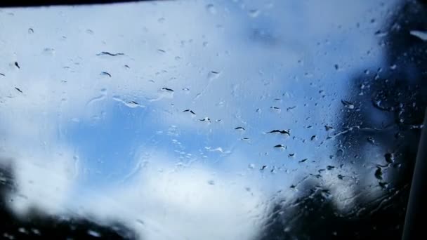 Φθινόπωρο στον αυτοκινητόδρομο σε μια βροχερή μέρα - defocused φόντο. Οι υαλοκαθαριστήρες του παρμπρίζ κινείται σταγόνες νερού — Αρχείο Βίντεο