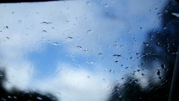 Autopista de otoño en un día lluvioso - fondo desenfocado. Gotas de agua en movimiento en los limpiaparabrisas — Vídeo de stock