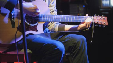 Gitarist akustik gitar çalar ve mikrofon gece kulübü, Mavi ışıklar şarkı söylüyor, yakın çekim