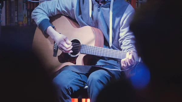 Close up view of guitarist plays acoustic guitar in night club — Stock Photo, Image