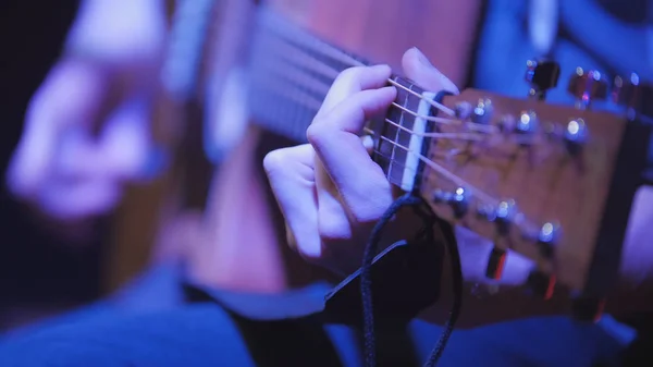 Музикант в нічному клубі гітарист грає на акустичній гітарі, вкрай крупним планом — стокове фото