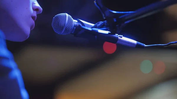 Молодий чоловік співає на мікрофон у нічному клубі, крупним планом — стокове фото
