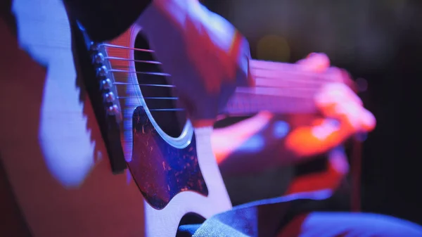 Музикант в нічному клубі - гітарист грає на блюзовій акустичній гітарі, вкрай крупним планом — стокове фото
