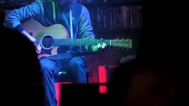 Guitarrista toca la guitarra acústica en club nocturno, de cerca — Vídeos de Stock