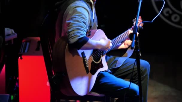 Guitarrista - jovem - toca guitarra acústica de concerto no clube noturno — Vídeo de Stock