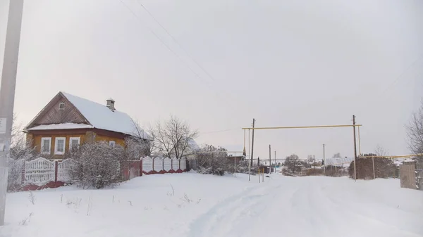 Camino de invierno en la típica campiña rusa pueblo en el centro del Volga, día frío como la nieve — Foto de Stock